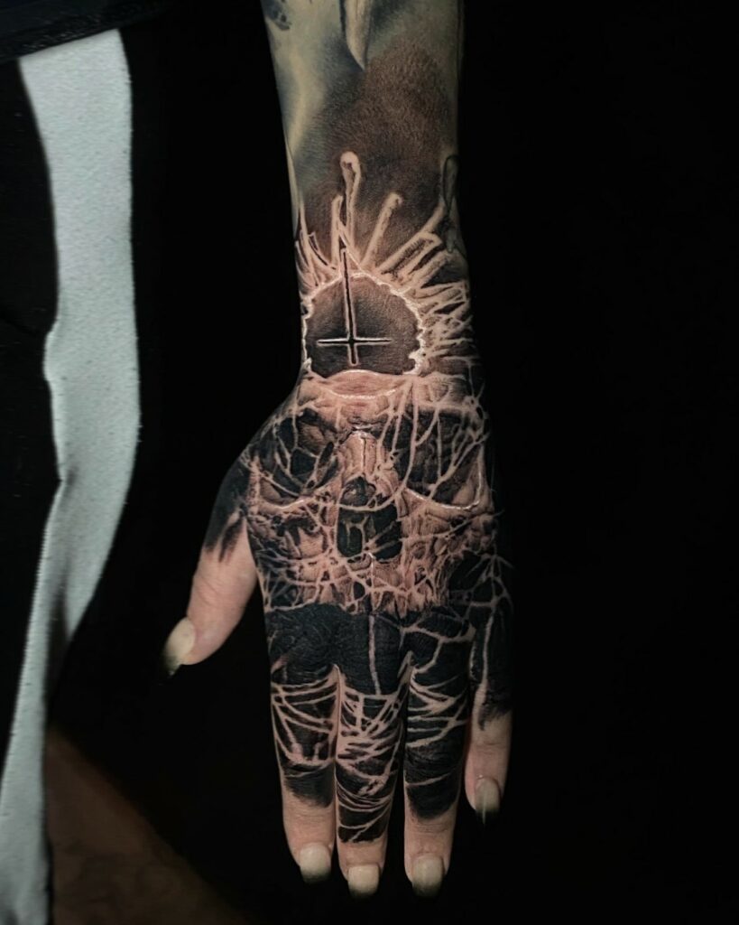 A Hand Displaying a Tattoo Featuring a Sun Intertwined with a Skull