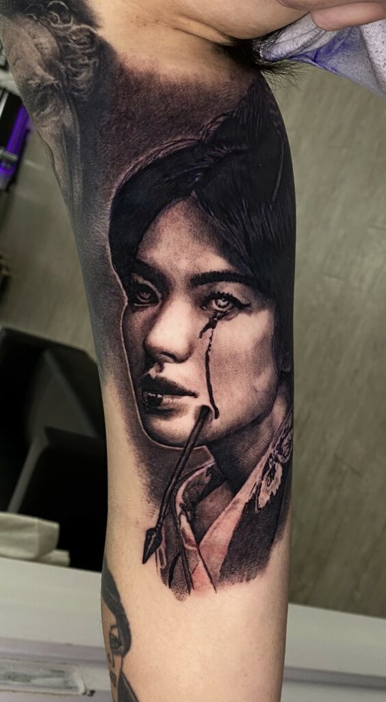 A Tattoo Depicting a Woman Holding a Knife