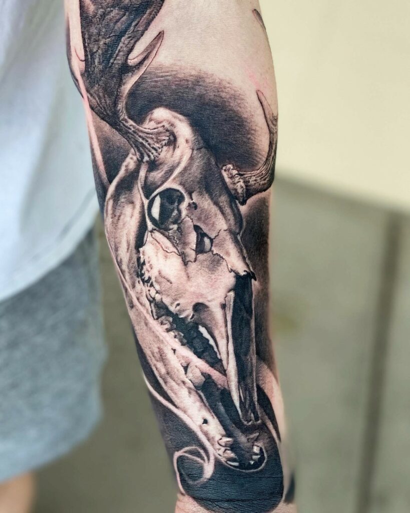 A Detailed Black and White Tattoo Depicting a Deer Skull