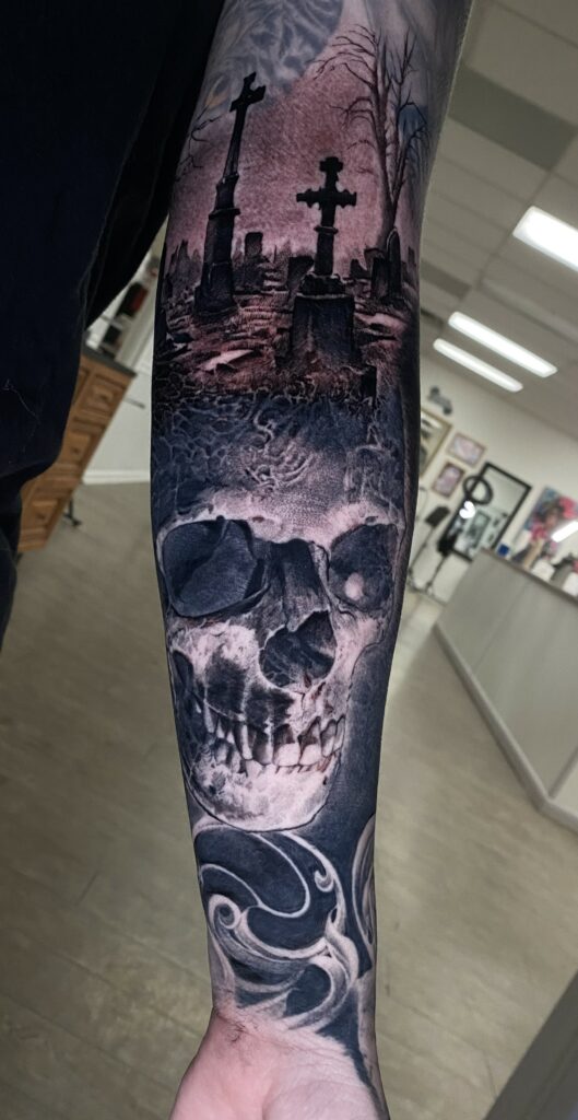A Detailed Tattoo Featuring a Skull and a Graveyard
