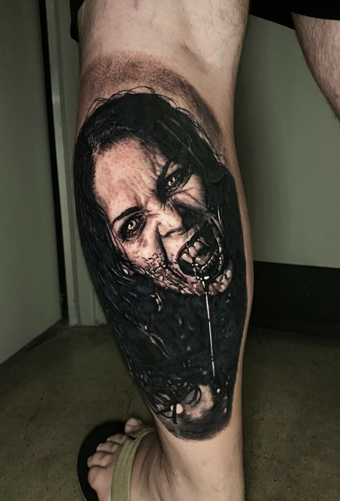 A Leg Tattoo Featuring a Woman with a Striking Zombie Face