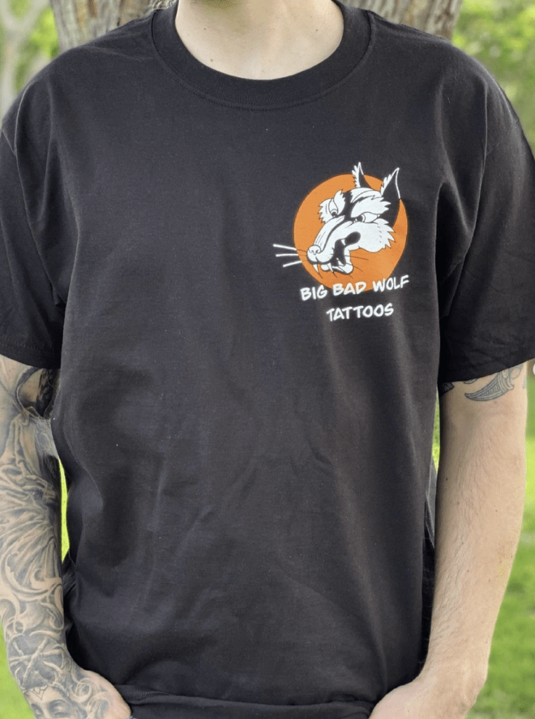 A Man Dressed in a Black Shirt Adorned with an Orange